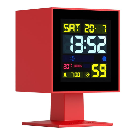 Red LCD alarm clock with glowing display, shown from a slight side angle.