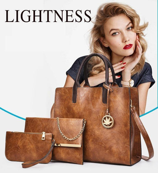Tan leather tote held by model, with matching coin purse and zip pouch.