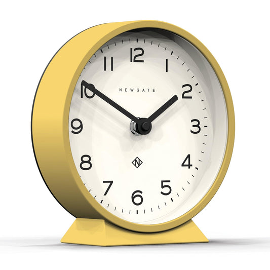 Yellow round mantel clock with white face, black hour marks, and twin hands