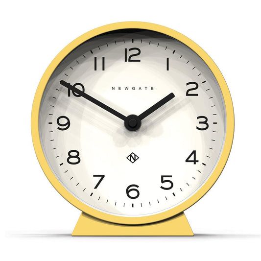 Yellow mantel clock with white dial, black hands, and round glass-front case