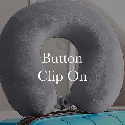 Grey travel neck pillow showing button clip attachment near center opening