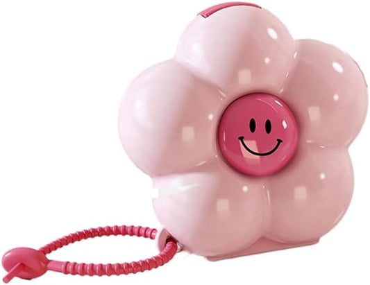 Pink flower-shaped portable pill box with smiley face and red rope handle