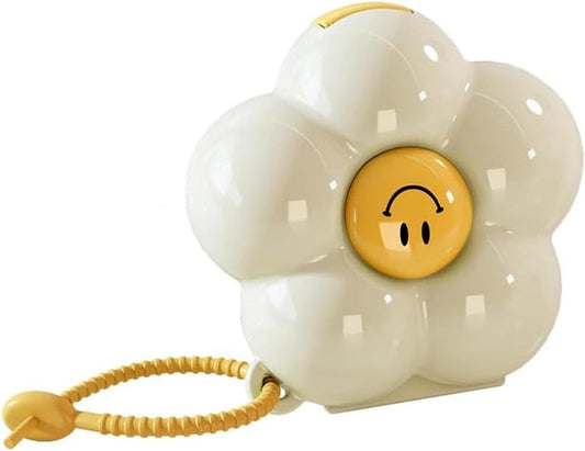 White flower-shaped pill box with yellow smile button and cord