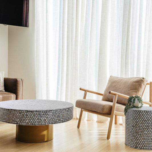 Round black side table with gold base and mother-of-pearl geometric inlay surface