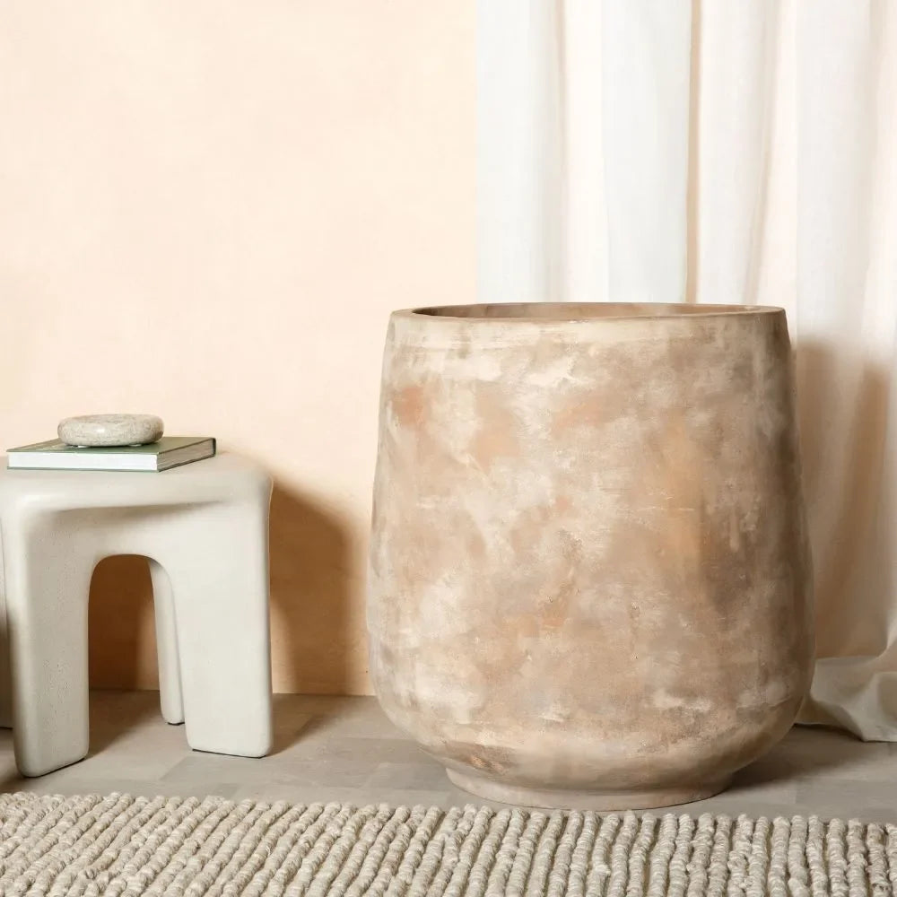 Oversized beige stone-look planter urn with wide opening and rounded tapered body
