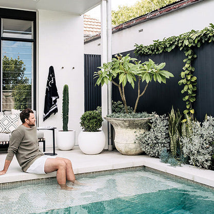 Muffin Top planter with large gray round pot and assorted plants beside pool