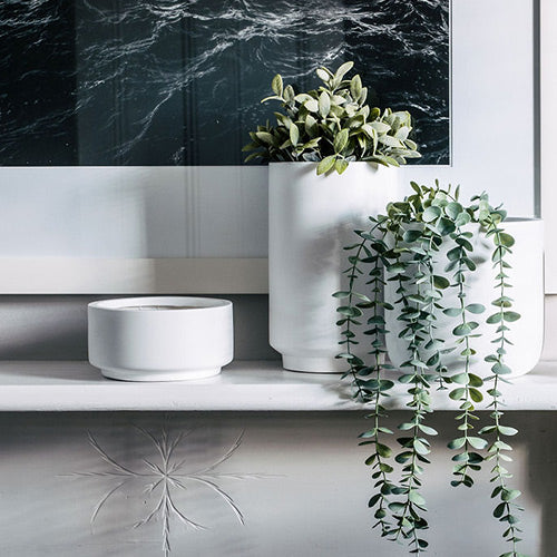 White cylindrical planter set with two large pots and one smaller pot, open rims.