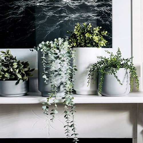 Gray cylindrical planter set with three pots, round openings and straight sides.