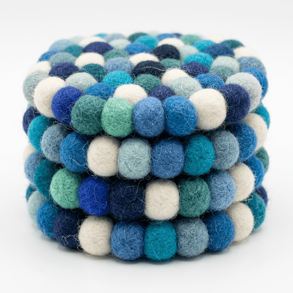 Close-up of round wool felt coaster with tightly packed pom-poms in blue mix