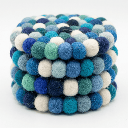 Close-up of round wool felt coaster with tightly packed pom-poms in blue mix