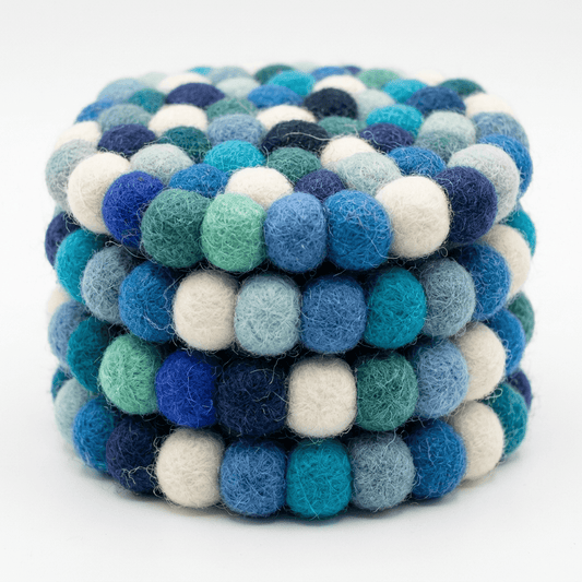 Close-up of round wool felt coaster with tightly packed pom-poms in blue mix