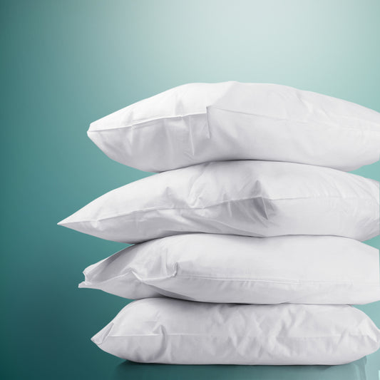 Stack of white bed pillows with plump, stitched edges
