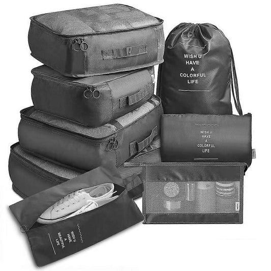 Travel packing cubes set with stacked dark gray cubes and a black drawstring bag