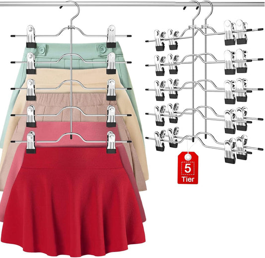 Set of multi-tier skirt and pants hangers with clips, holding skirts in pink and red.