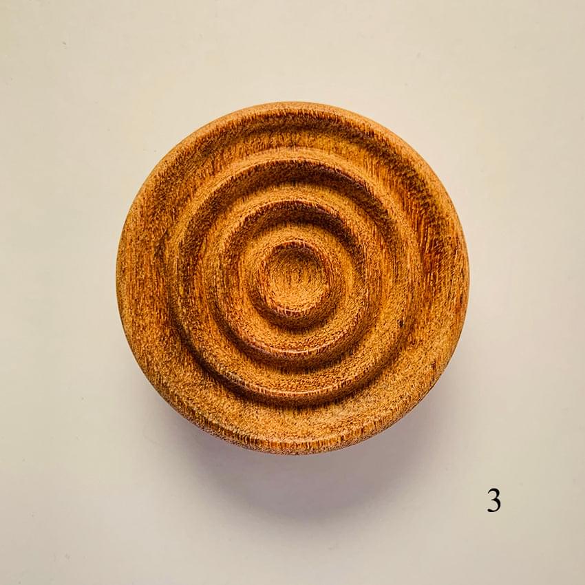 Round wooden diffuser with concentric spiral grooves, warm brown finish