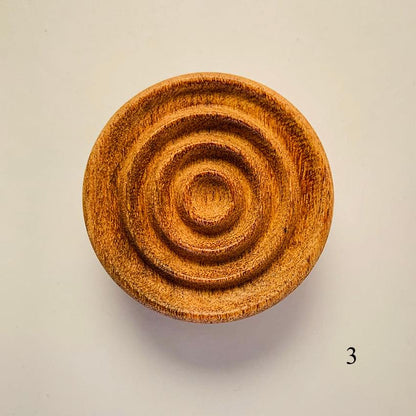 Round wooden diffuser with concentric spiral grooves, warm brown finish