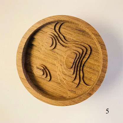 Round wooden diffuser lid with embossed cat face and swirling line carving