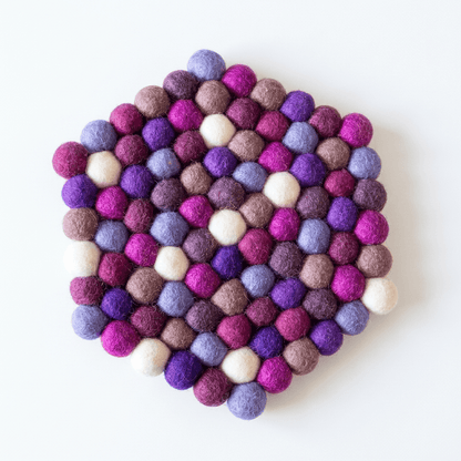 Round wool felt trivet with raised felt balls in purple, plum, and cream