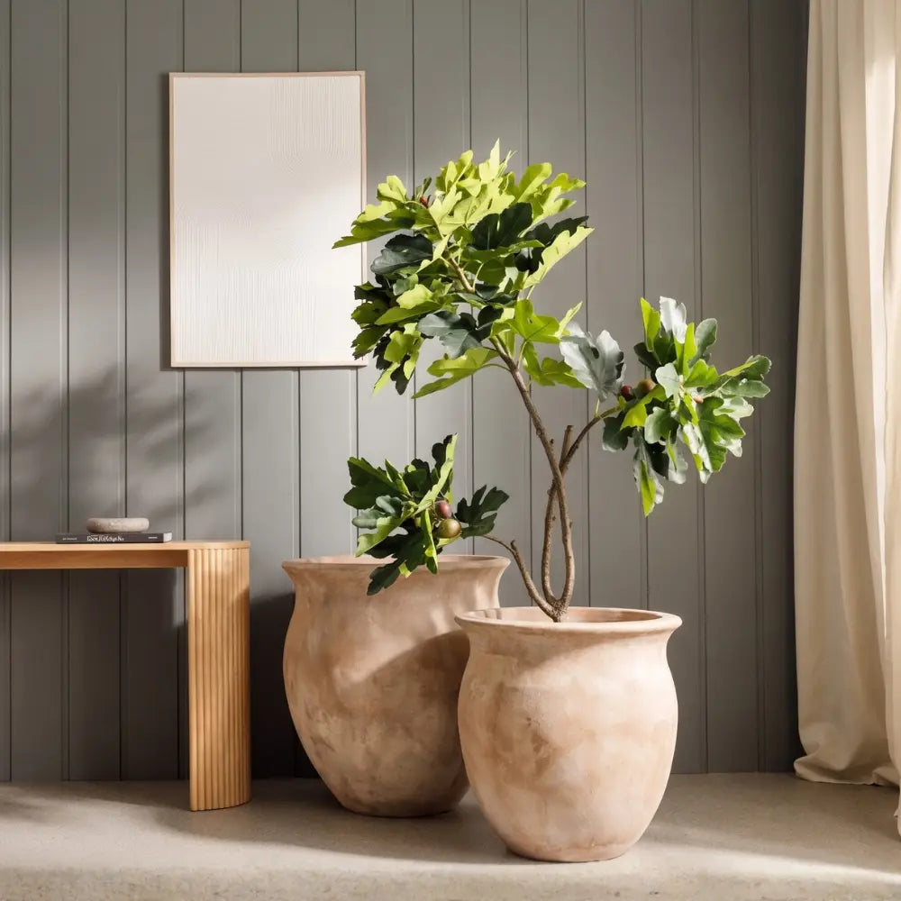 Three beige planters with flared rims, arranged with stems in the openings.