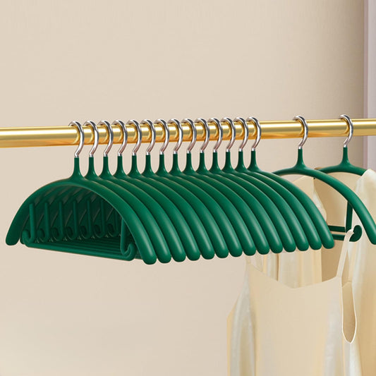 Set of green velvet non-slip hangers, nested on a metal closet rod.