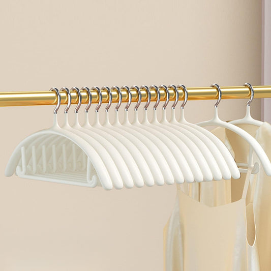 Set of white velvet clothes hangers on gold bar, rounded shoulders and notches