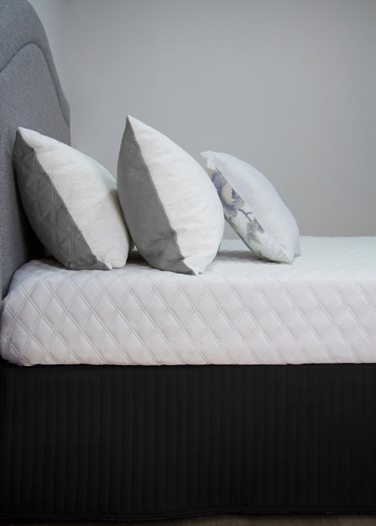 Quilted bed valance in dark gray with vertical pleats along the edge