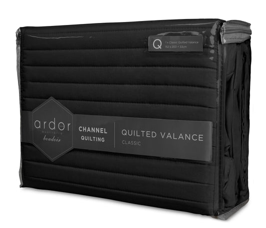 Quilted bed valance in black with horizontal stitching and draped corner