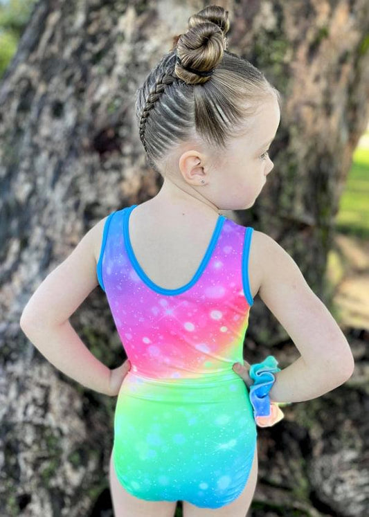 Girls sleeveless rainbow gradient leotard with racerback and blue trim, galaxy sparkles