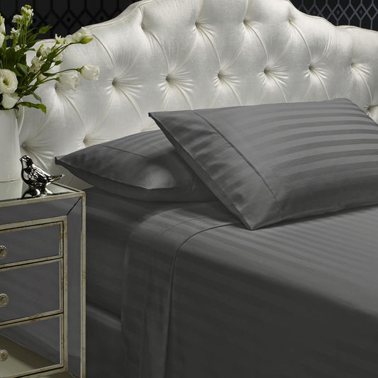 Charcoal gray striped sheet set with two pillowcases and flat sheet on bed