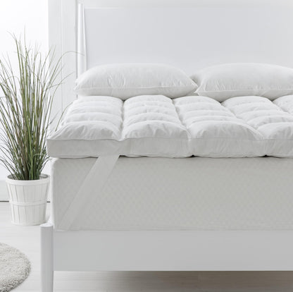 Single white duck down topper with two matching pillows on a bed