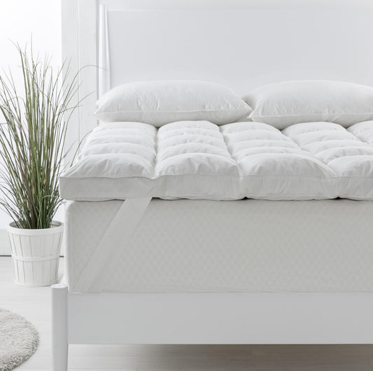 Single white duck down topper with two matching pillows on a bed