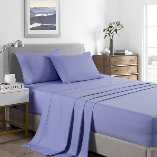 King mid-blue sheet set on bed, fitted sheet and pillowcases with matching pillows