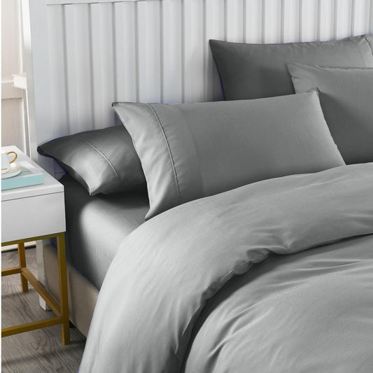 Grey queen duvet cover with two pillowcases and shams on bed