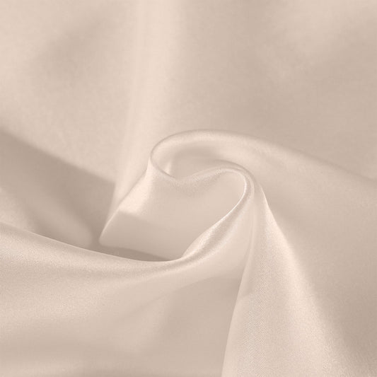 Champagne pink silk pillowcase fabric close-up with smooth sheen