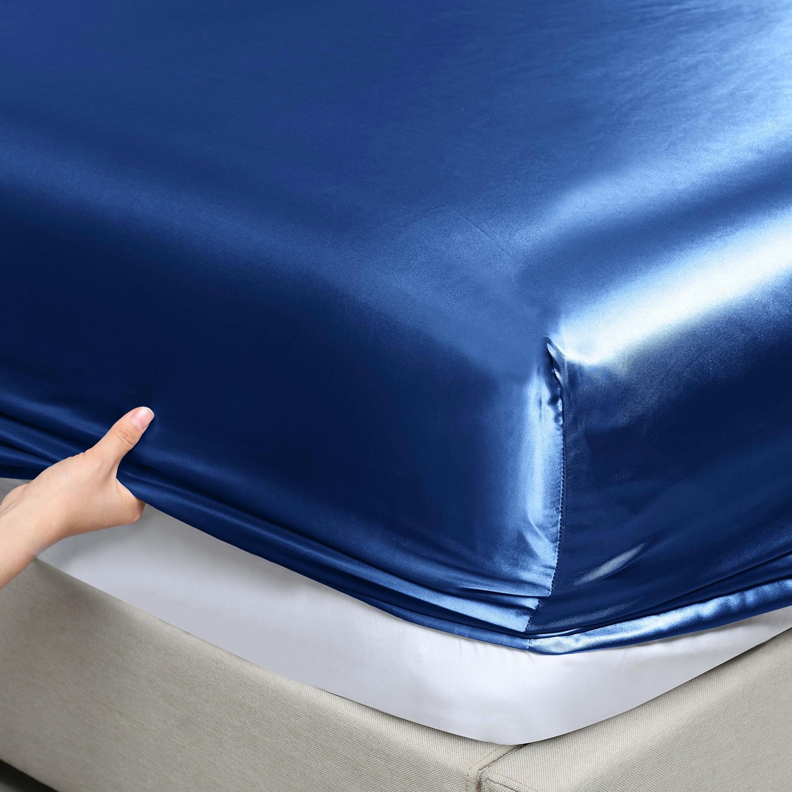 Navy satin fitted sheet corner with elastic edge seam detail