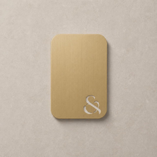 Brushed brass color swatch card with rounded corners and embossed logo on metal