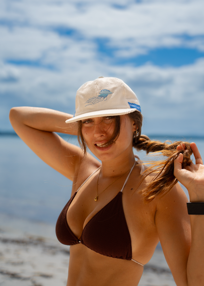 White sun cap with blue jellyfish patch on front, soft ribbed texture.