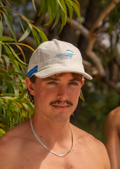 White corded cap with embroidered blue jellyfish and blue side label on brim.