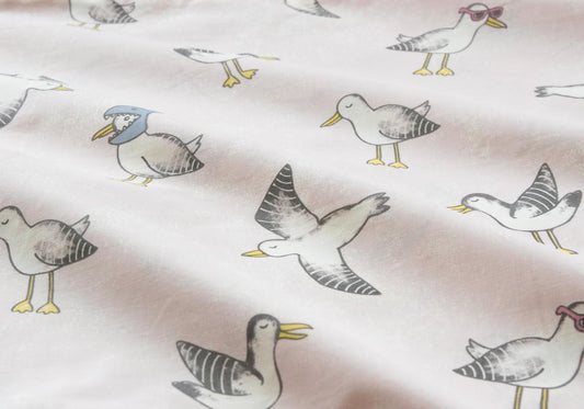 White quilt cover fabric with scattered seagull illustrations in gray and teal