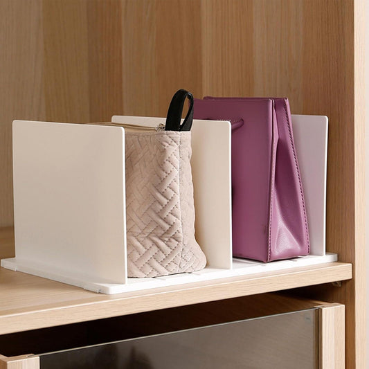 White shelf divider organizer separating handbags on a closet shelf