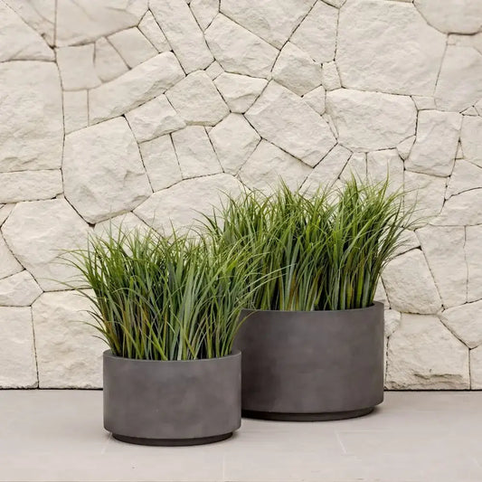 Round outdoor plant pot set with two dark gray planters and green grass