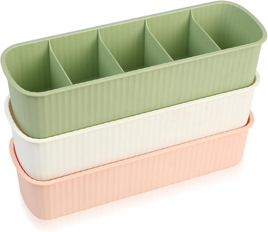 Three stacked storage drawers with green, white, and pink ribbed bodies and dividers