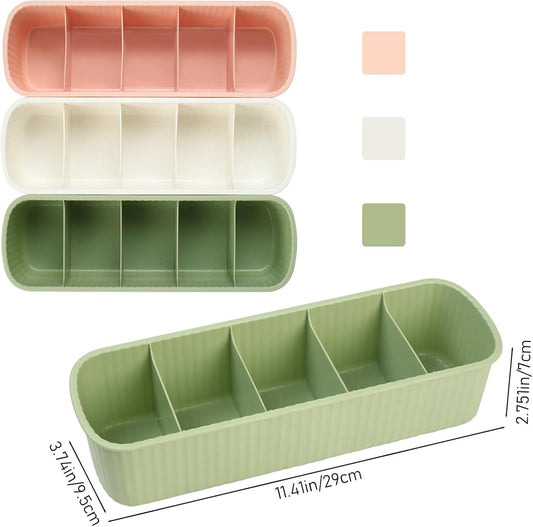 Set of three ribbed storage drawers in green, white, and pink, each with interior dividers