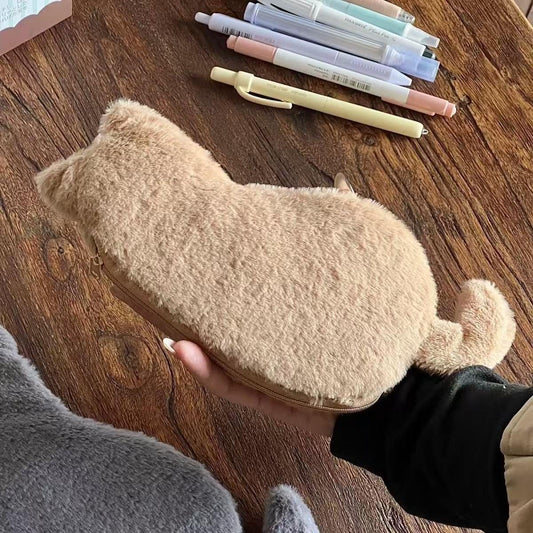 Khaki cat-shaped fuzzy zipper pouch with paw tail, held in hand