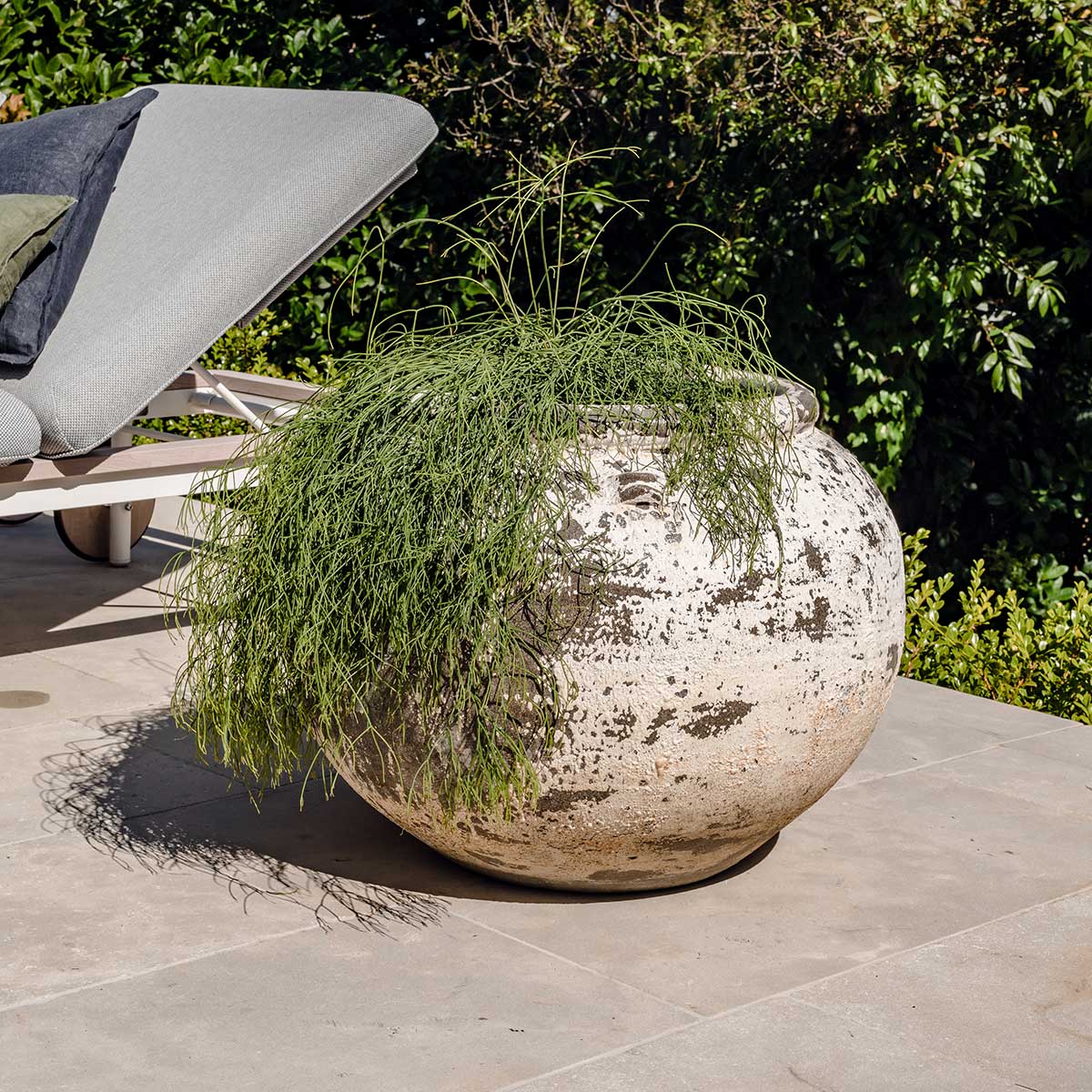 Phooket round planter pot with speckled white finish, filled with trailing green grass