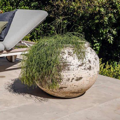 Phooket round planter pot with speckled white finish, filled with trailing green grass
