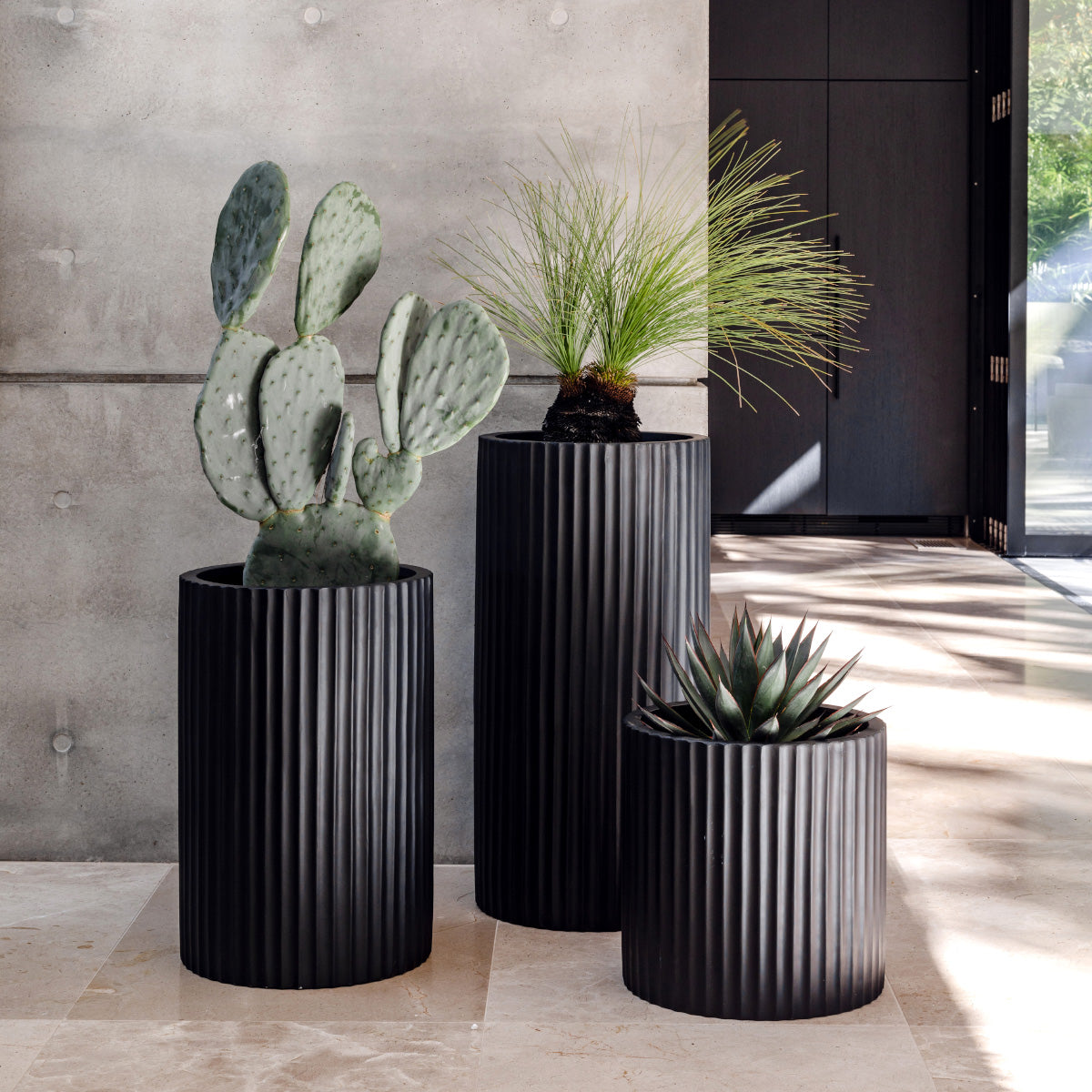 Dark grey ribbed planters, three cylindrical pots with vertical fluted sides