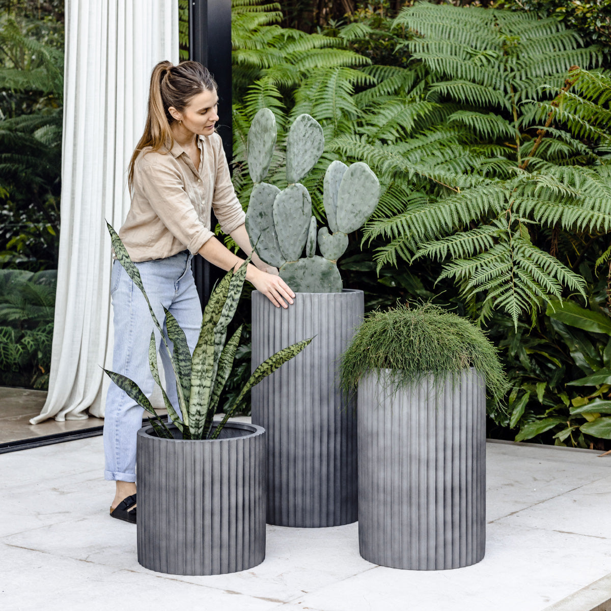 Charcoal grey ribbed planters, three cylindrical pots with vertical fluted texture