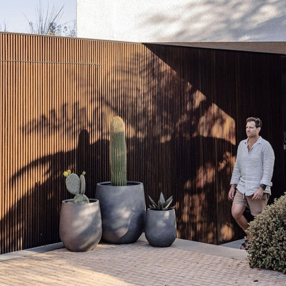 JITT planter set: four matte gray pots with succulents on a patio wall