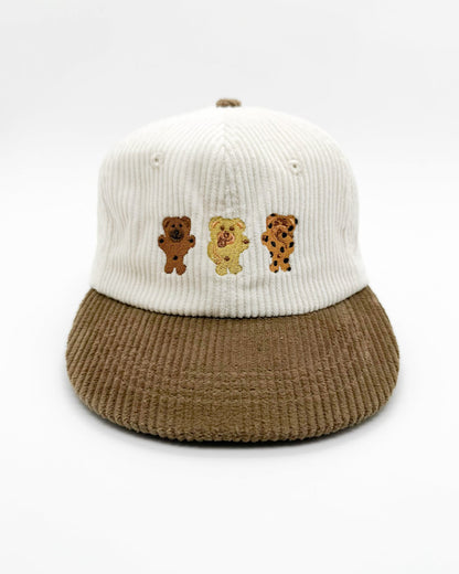 Two-tone knit bear hat with white crown, brown brim, and three bear patches